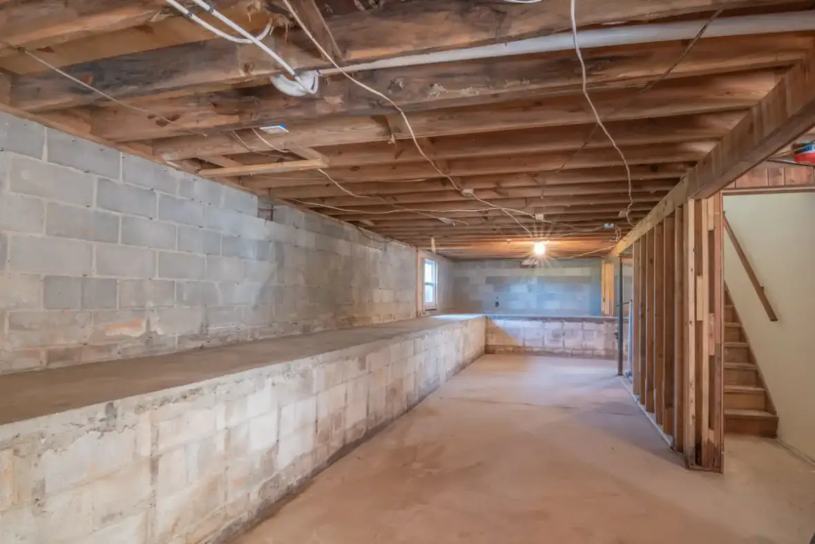 Below-grade masonry wall and joist bays before framing and board