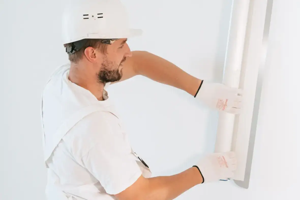 Drywall panel lifted into place against open framing during installation